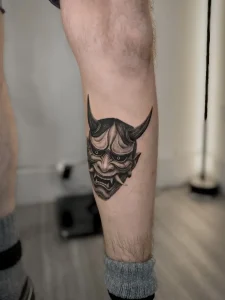Japanese Oni mask leg tattoo in Calgary by oleg.r.tattoo